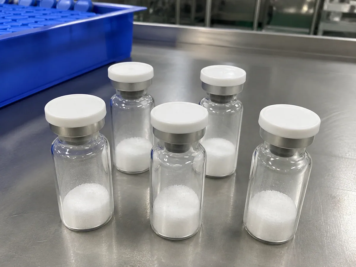 Five unlabeled vials containing lyophilized peptide research material