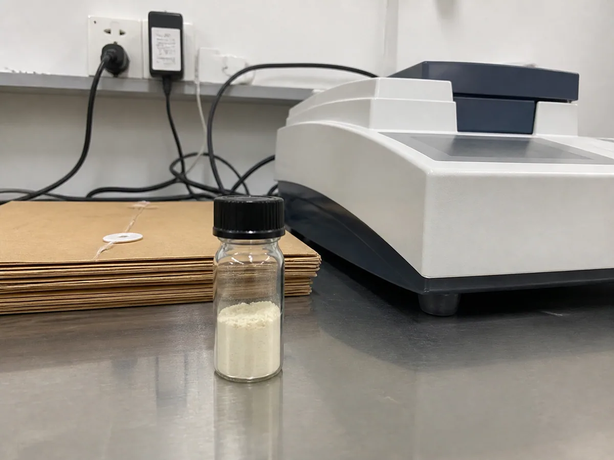 White peptide material beside laboratory analytical equipment